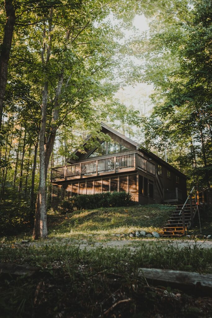 brown wooden house surrounded by green trees during daytime dom szkieletowy