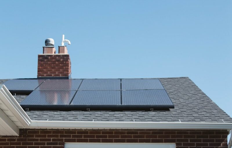 brown brick house with solar panels on roof