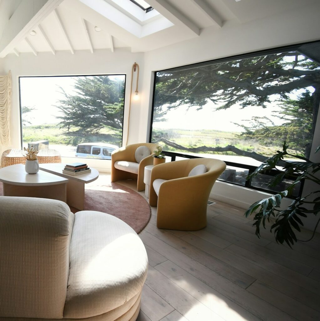 a living room filled with furniture and large windows